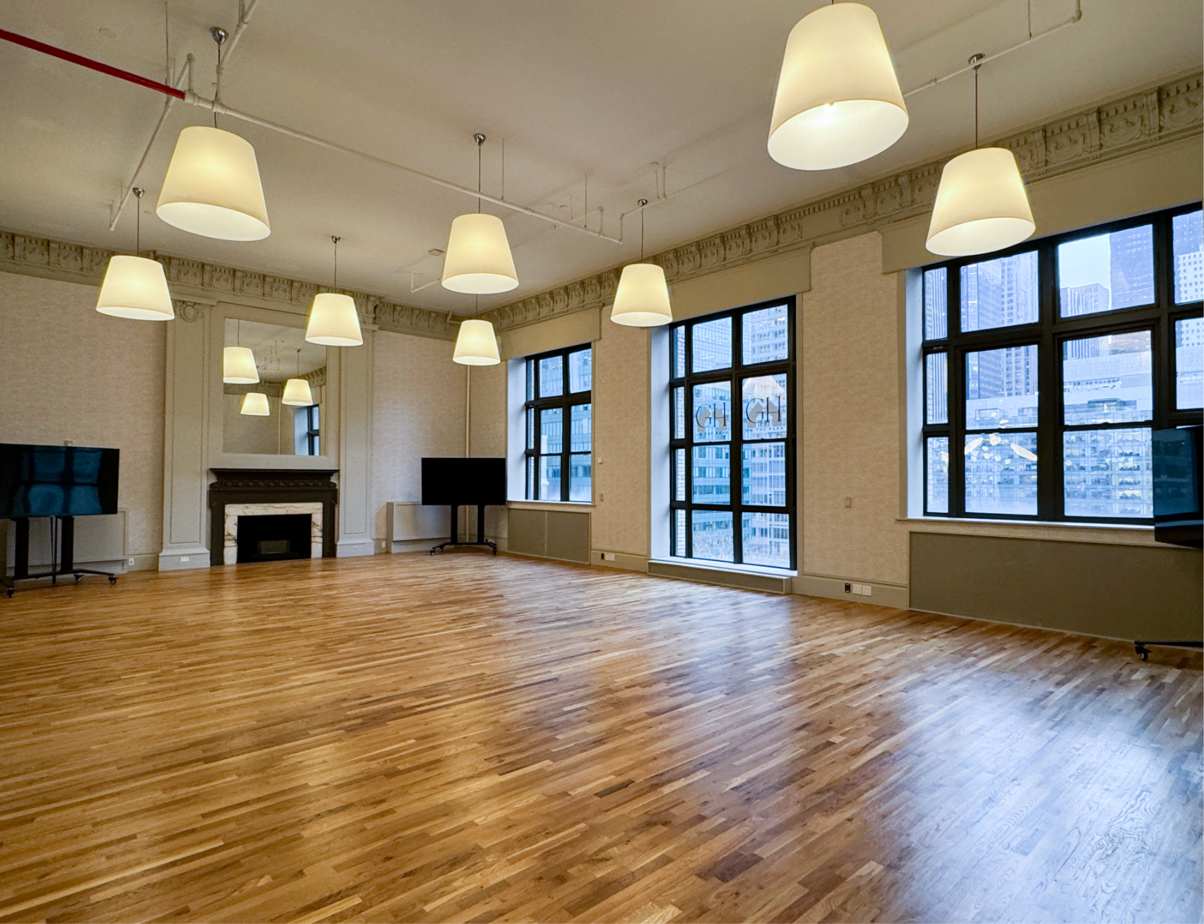 a large empty room with hardwood floors and lots of windows