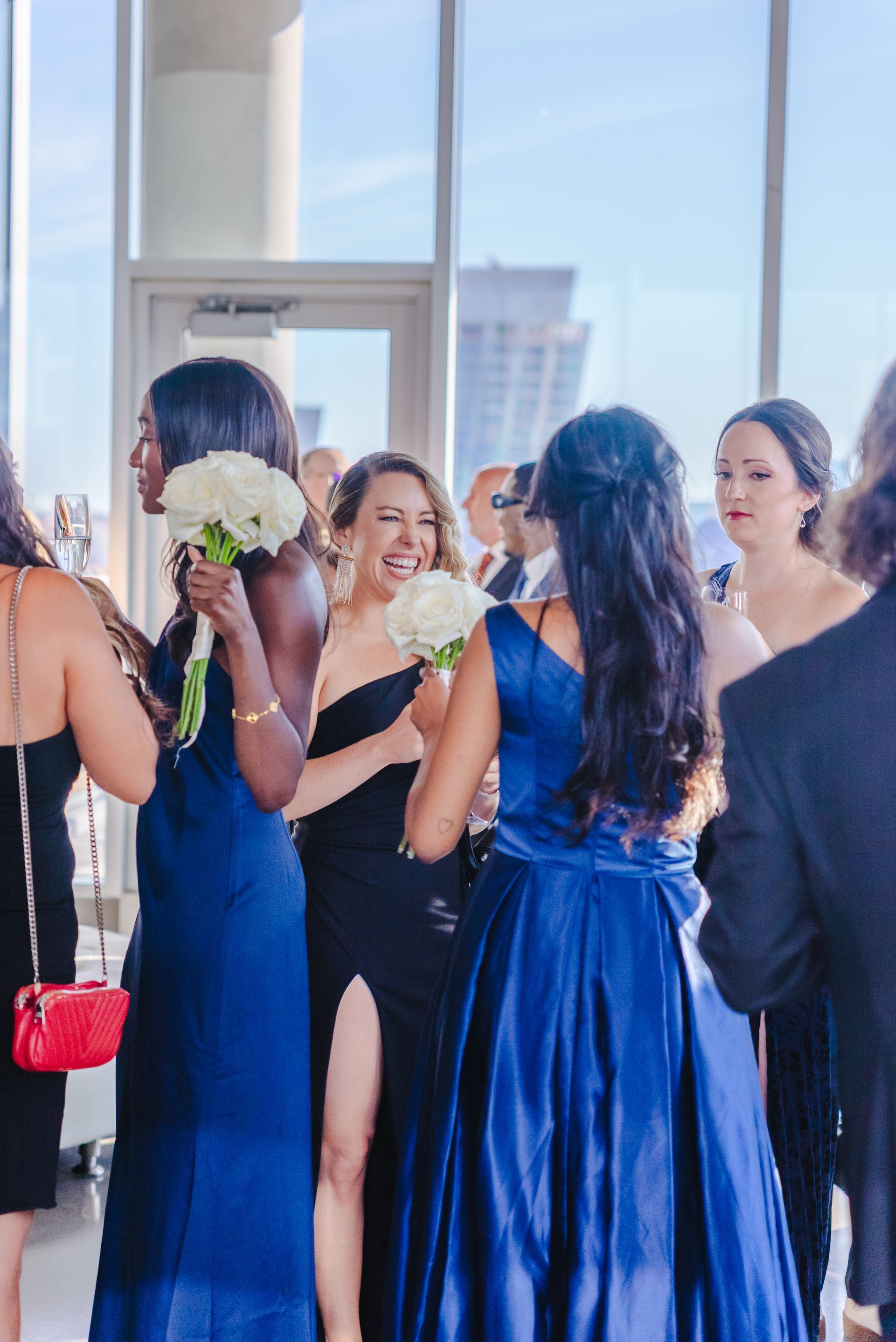 Restaurant interior with tables set for dinner, overlooking a lit-up cityscape at night.
