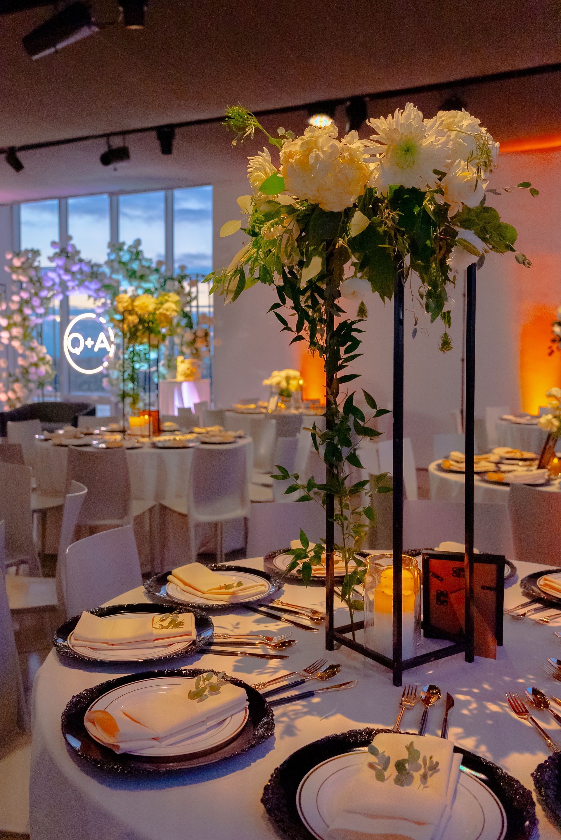 Elegant wedding reception table setting with floral centerpiece and place settings.