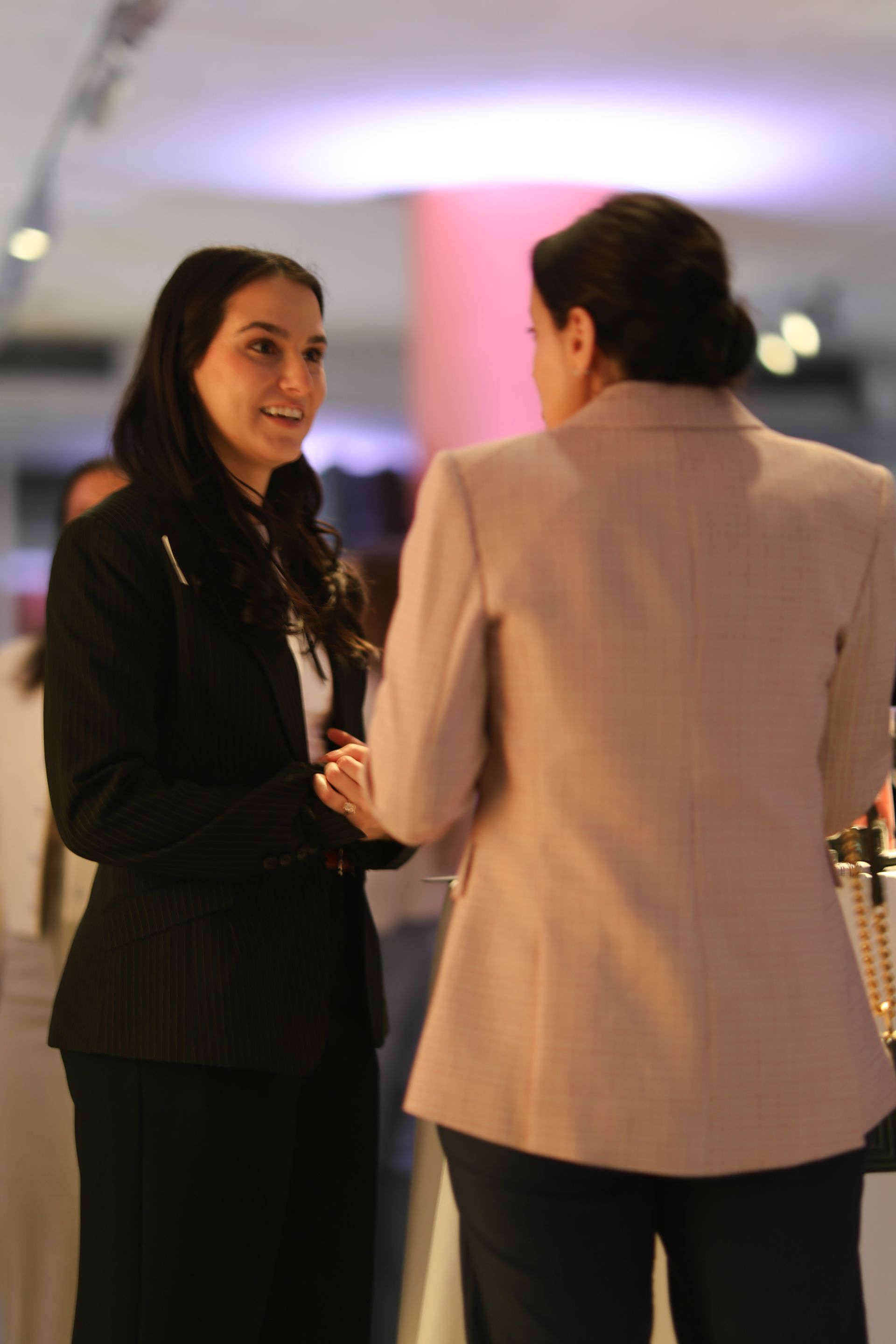 Two women are standing next to each other and talking