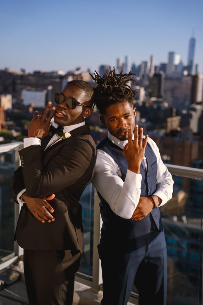 Two men in suits are standing next to each other on a balcony.