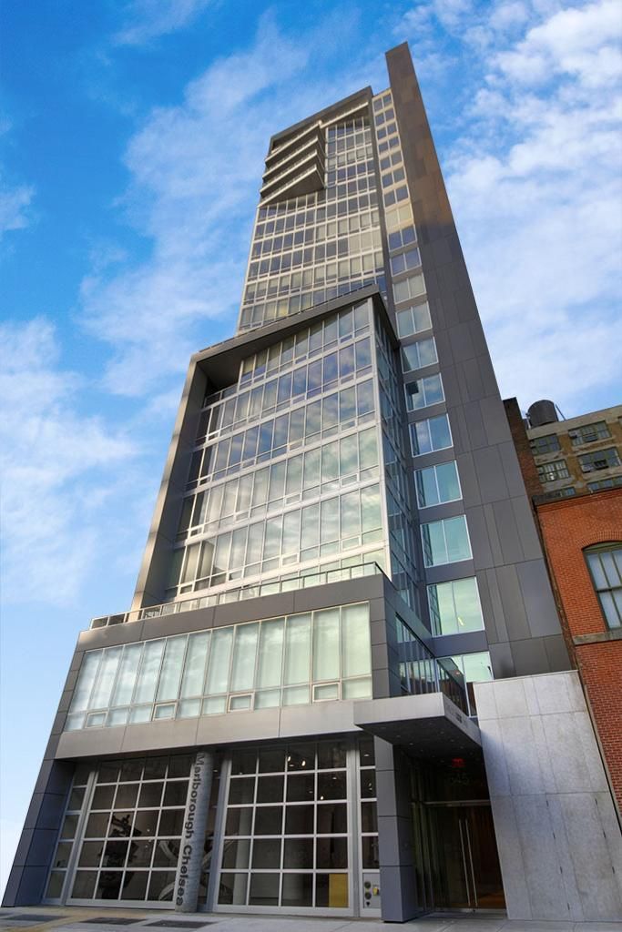 a tall building with a lot of windows and a blue sky in the background
