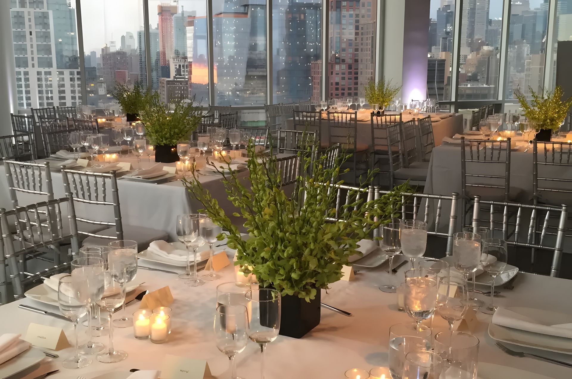 A table set for a wedding reception with a view of the city skyline.