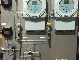 Two ABB EL3060 industrial gas analyzers mounted on a stainless steel panel with plumbing and electrical components.