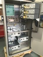 An open industrial equipment cabinet containing multiple rack-mounted electronic modules and internal wiring.
