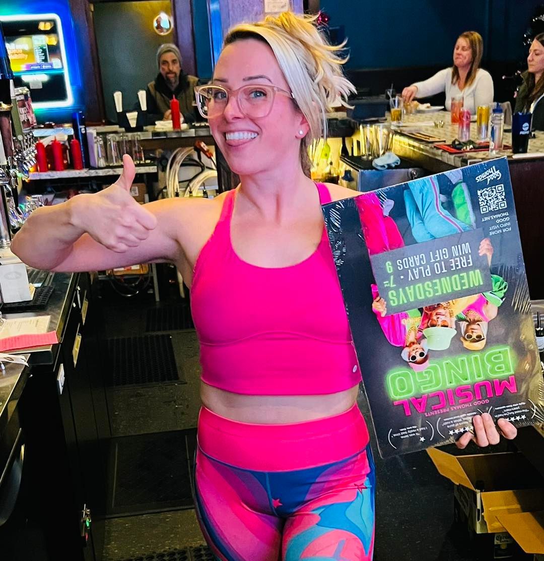 A woman giving a thumbs up while holding a sign that says ' o'clock ' on it