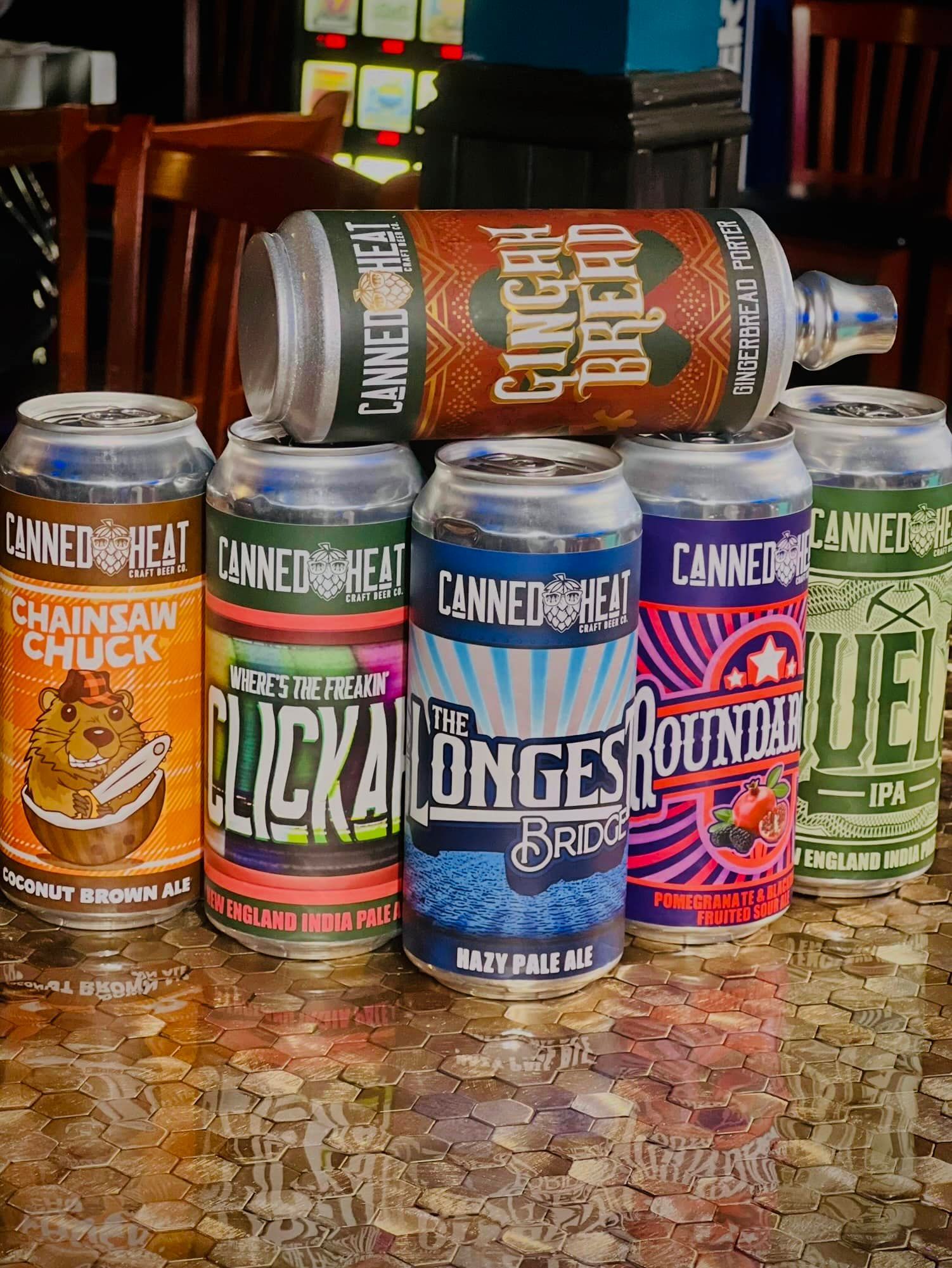 A group of cans of beer are stacked on top of each other on a table.