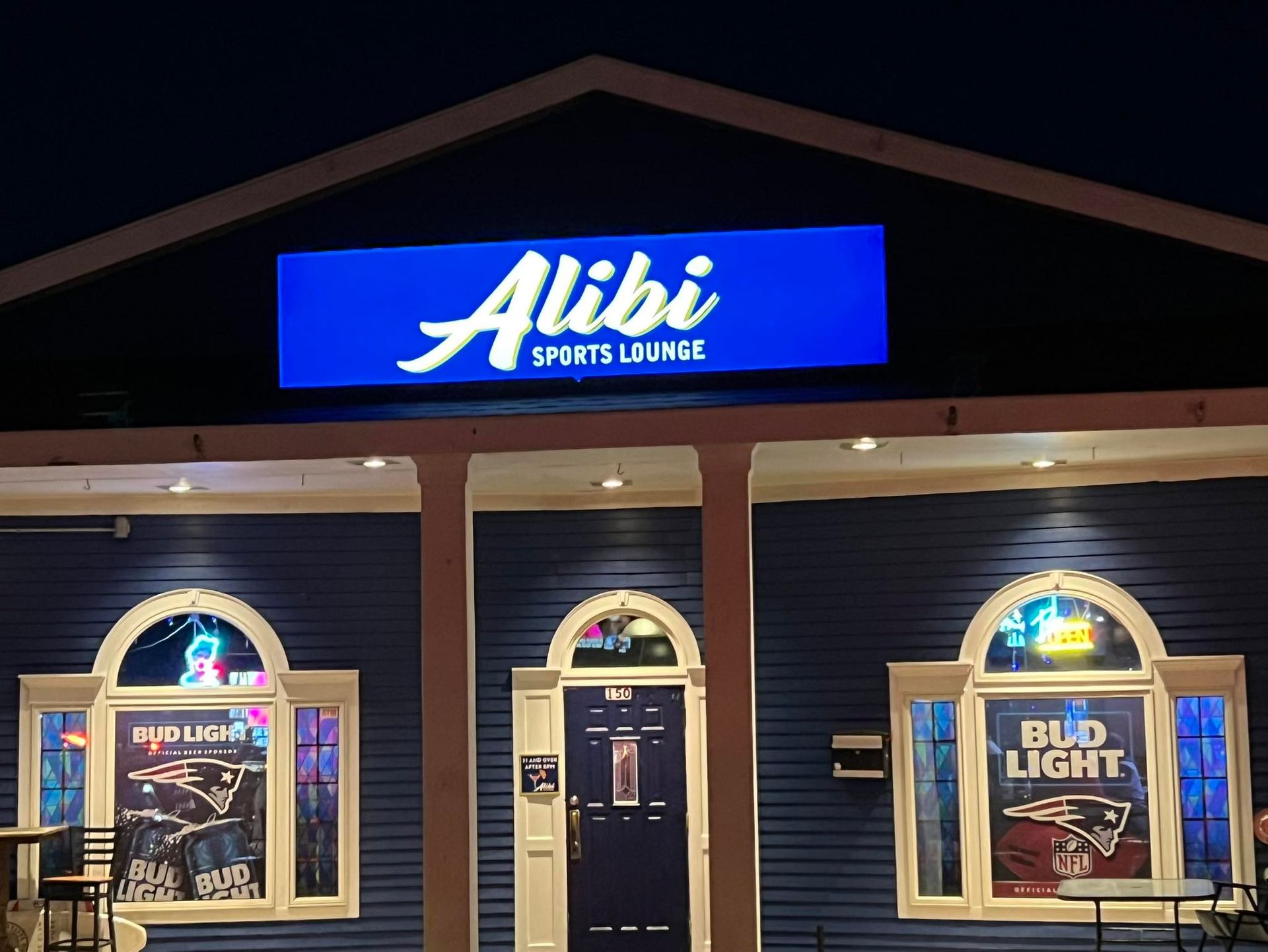 A blue building with a sign that says ' alibi sports lounge ' on it
