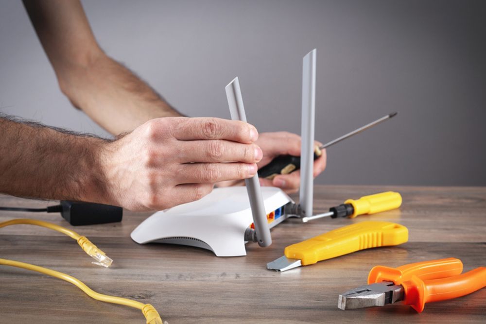 Man fixing the router using tools — Mesh WiFi Network in Tamworth, NSW