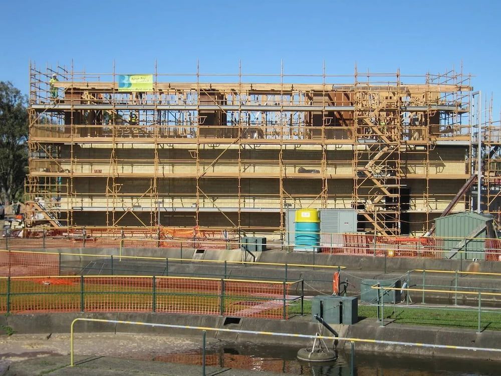 A Large Building Under Construction With Scaffolding Around It — Byron Bay Scaffold in Kinvara, NSW