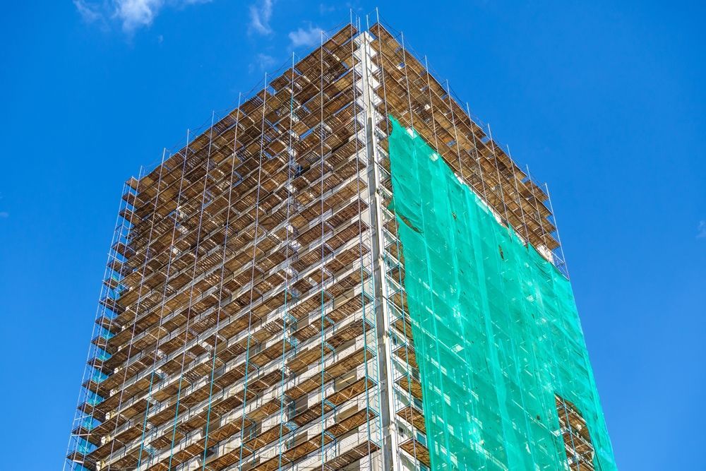 A Tall Building is Being Built With Scaffolding — Byron Bay Scaffold in Kinvara, NSW
