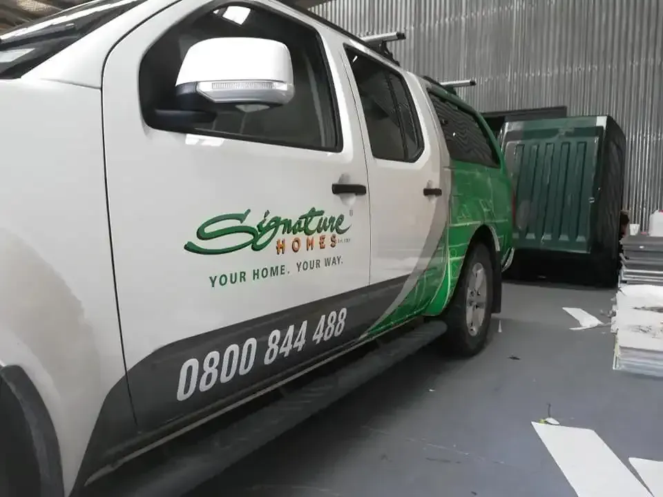 a signature homes van is parked in a garage