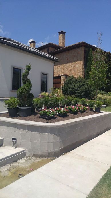 A house with a lot of potted plants in front of it.