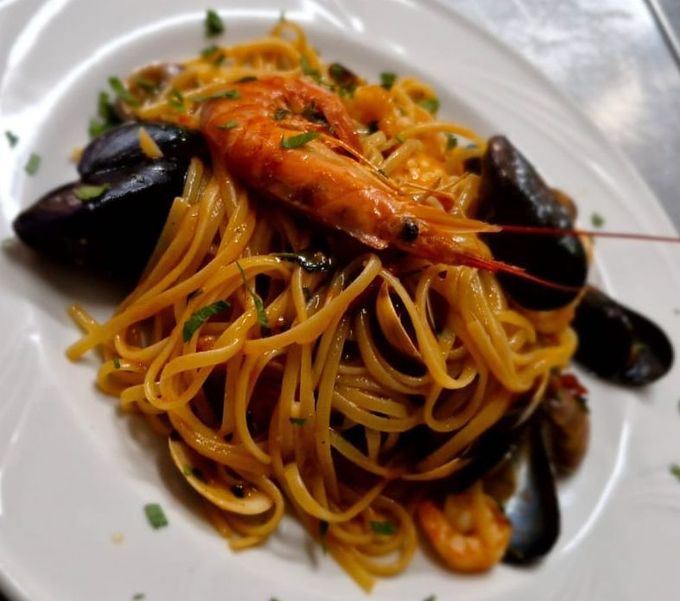 Pasta ai frutti di mare con cozze, gamberi e spaghetti su un piatto bianco
