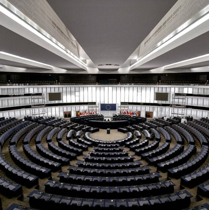 A large auditorium filled with rows of tables and chairs