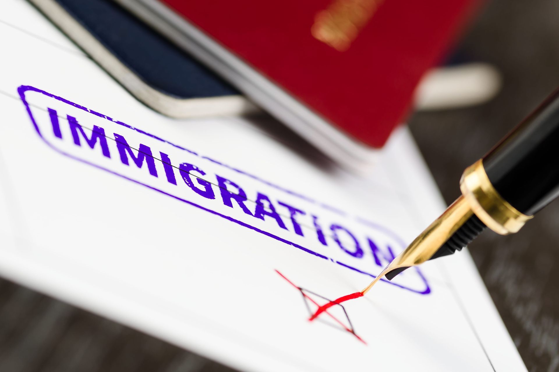 Immigration form with a pen signing a red check mark on paper