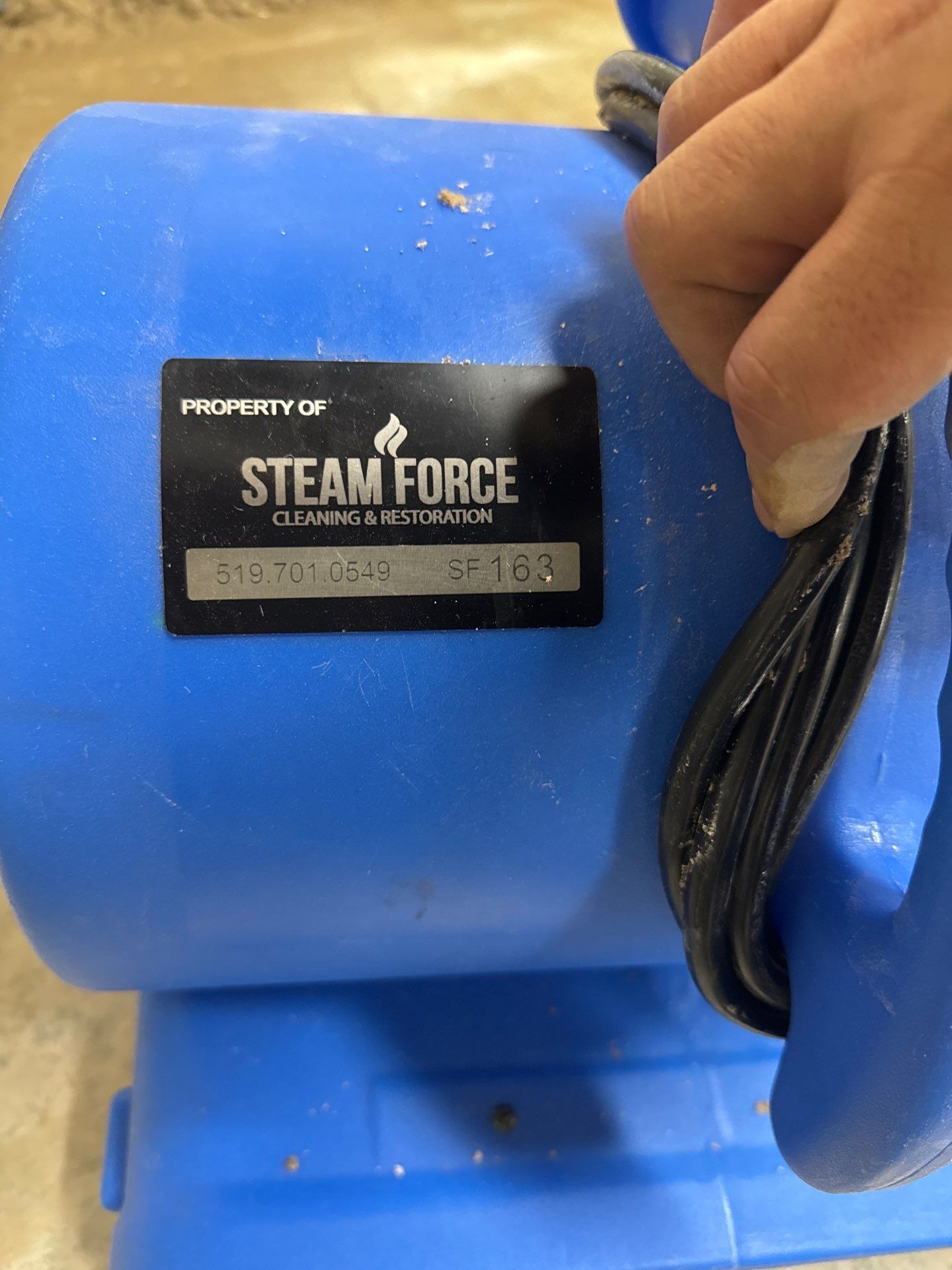 A person is holding a blue steam force machine.