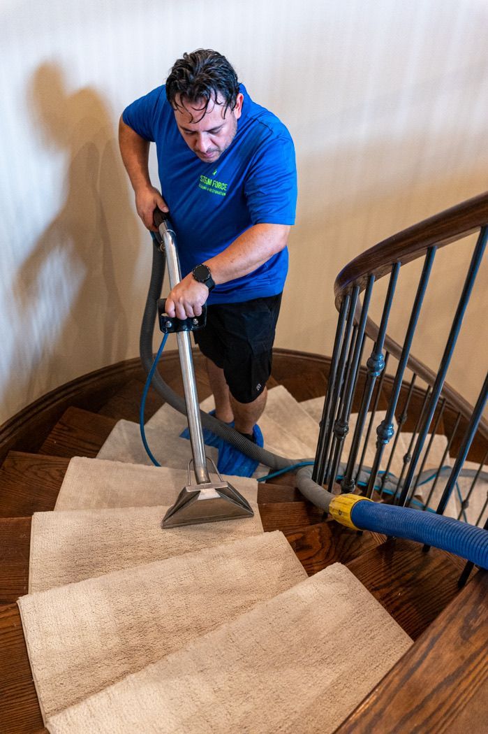 A man is cleaning a staircase with a vacuum cleaner.