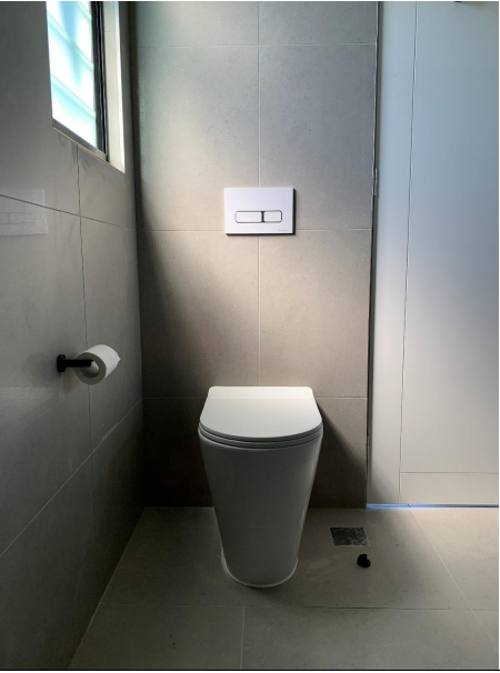 A Grey Metal Roof With A White Gutter And Downpipe Attached — Mates Plumbing and Gas in Lammermoor, QLD