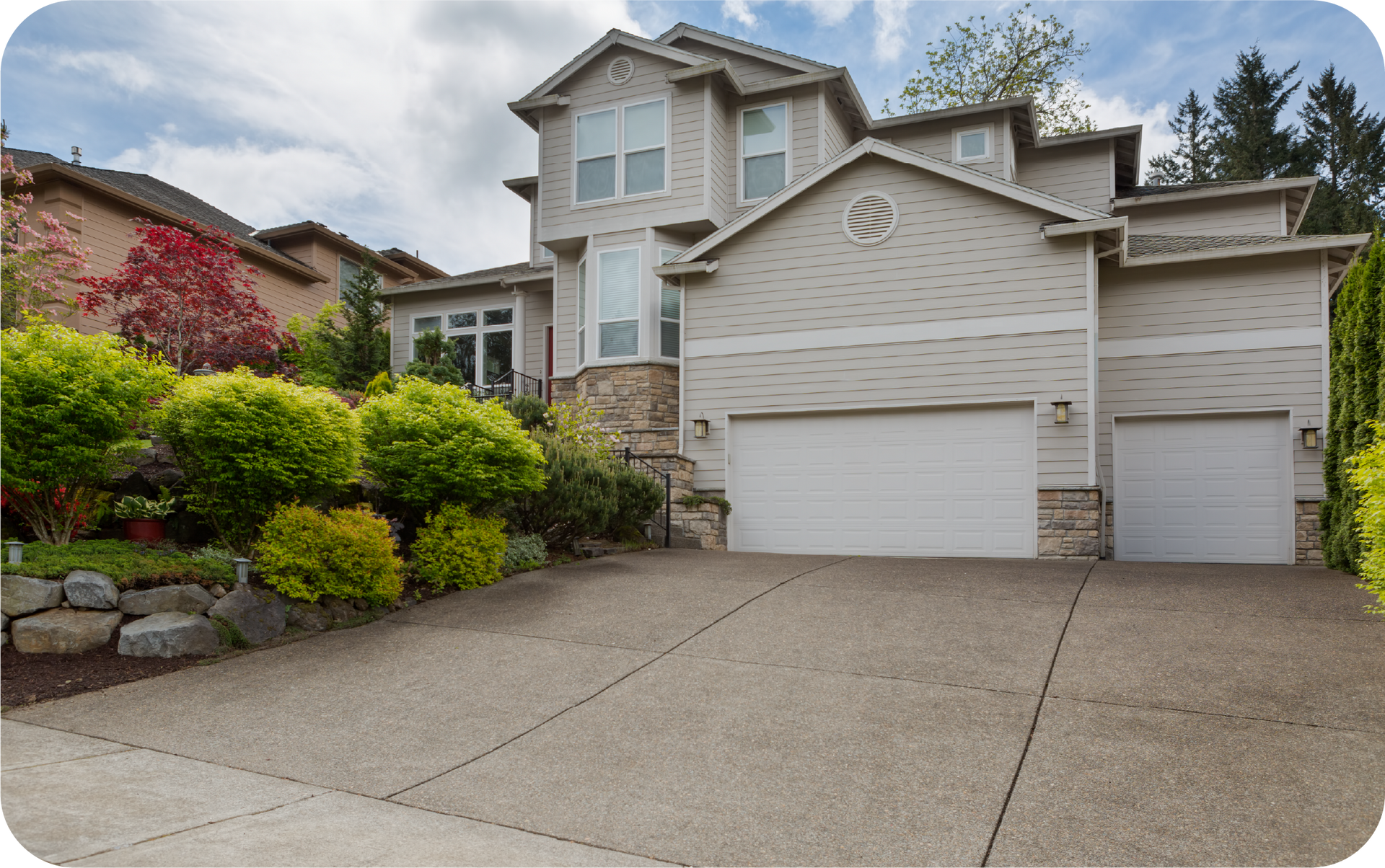 A large house with two garage doors and a driveway