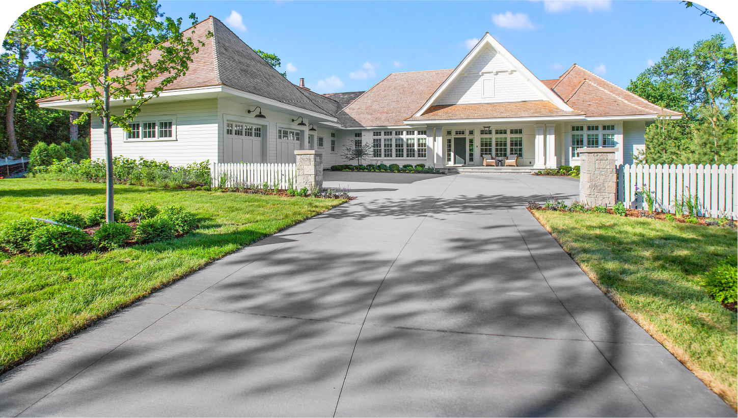 A large white house with a driveway leading to it.