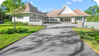 A large white house with a driveway leading to it.