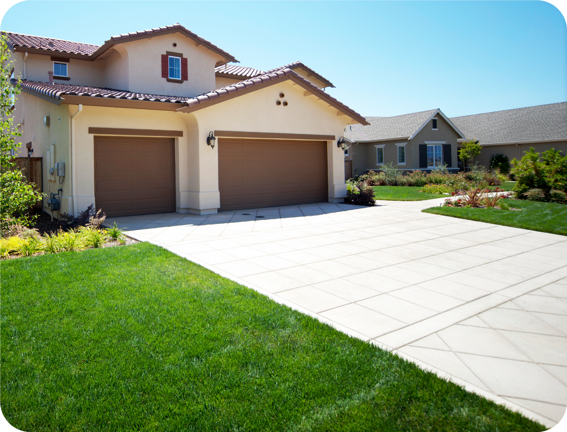 A house with two garage doors and a concrete driveway