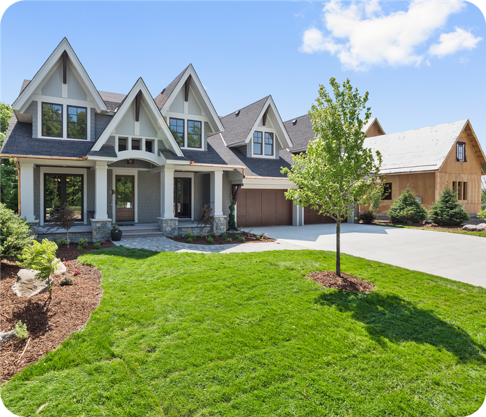 A large house with a lush green lawn in front of it