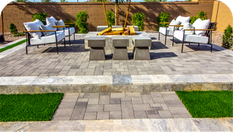 A patio with a fire pit and chairs on it