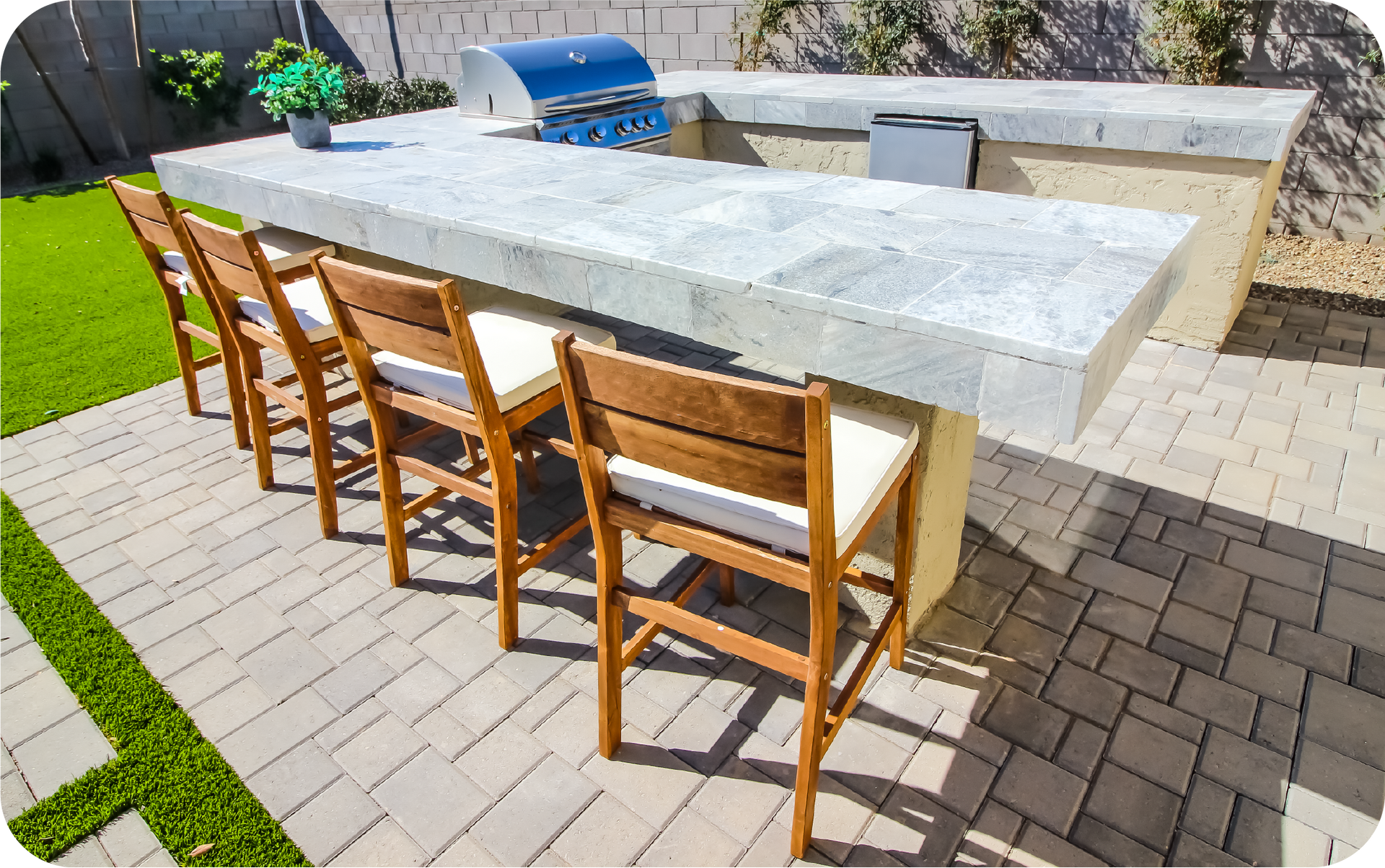 A patio with a table and chairs and a grill.