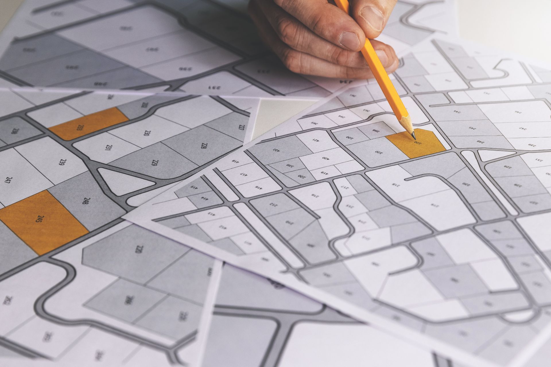 A person is drawing a map with a pencil on a piece of paper.