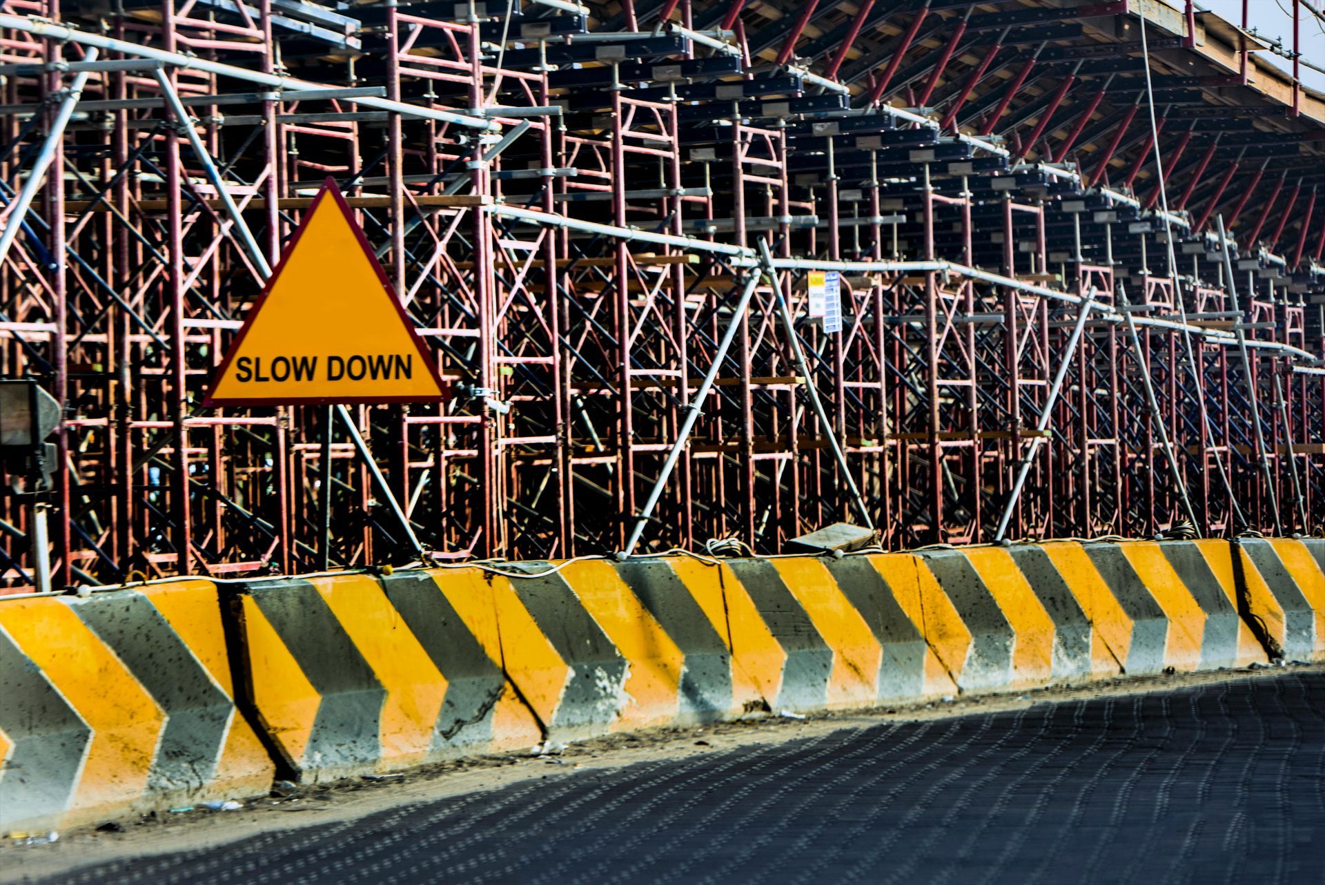 A construction site with a yellow sign that says slow down