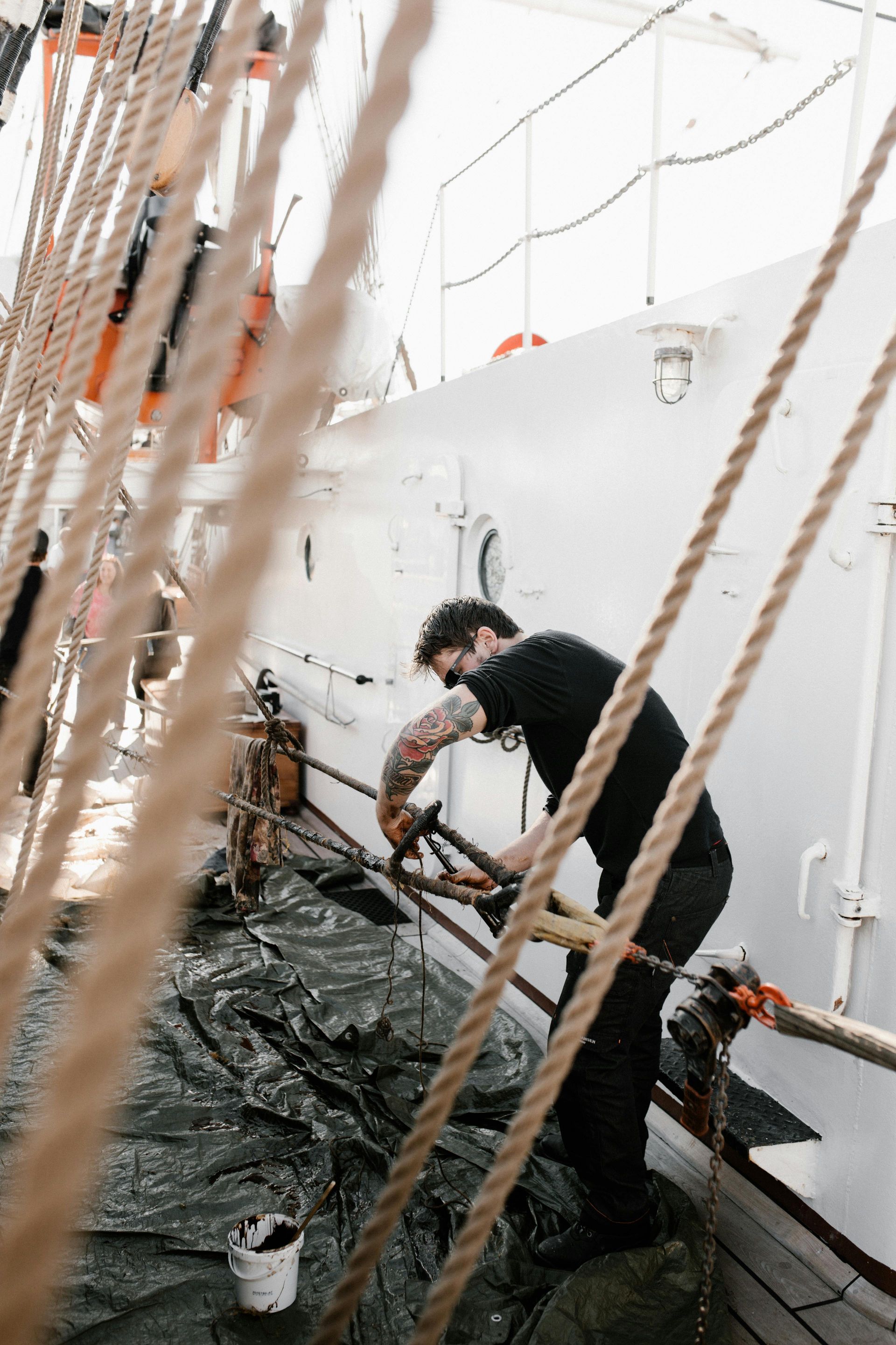 A man is working on the side of a boat.