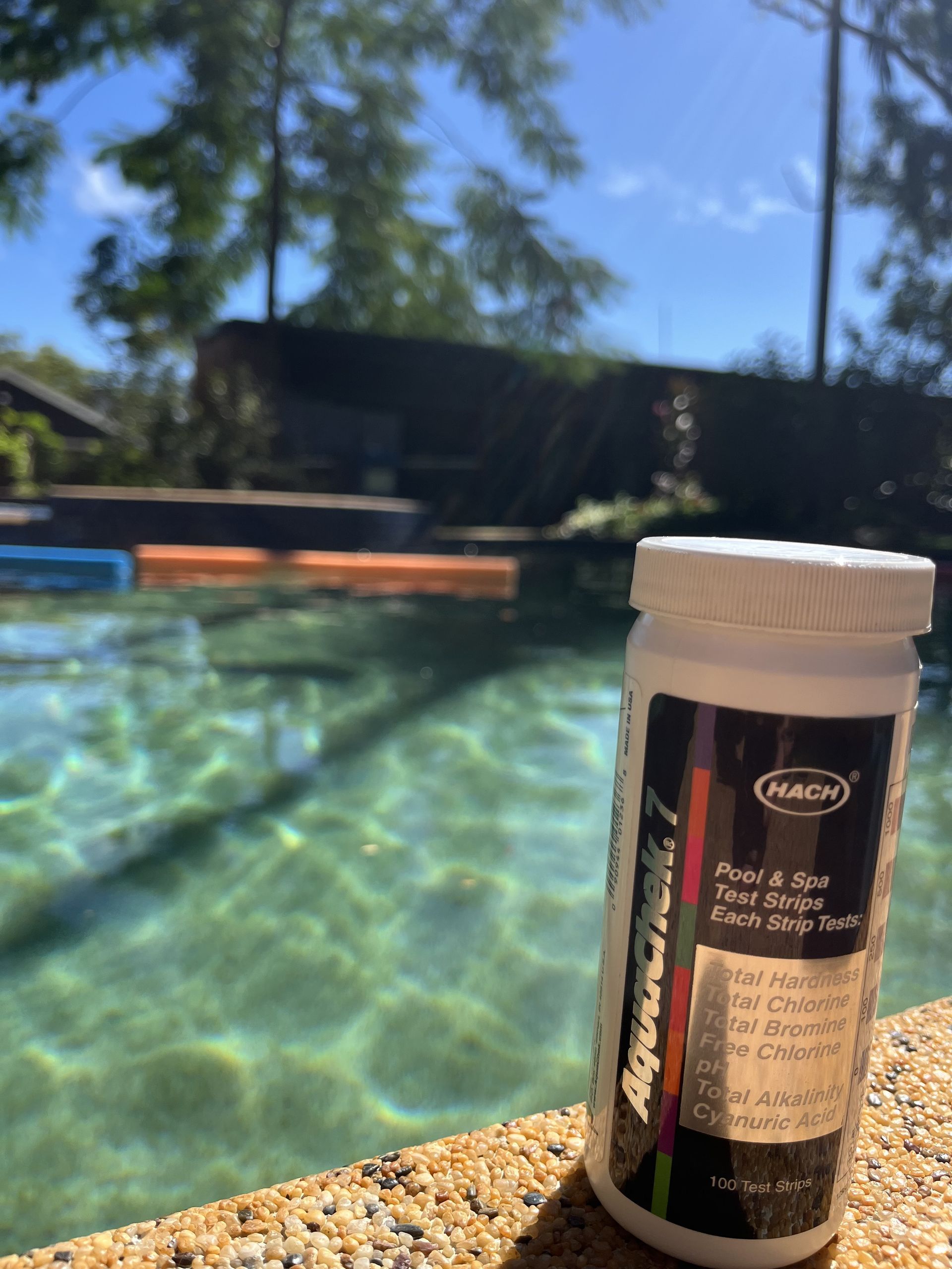 A Person is Measuring the Ph of a Swimming Pool With a Test Strip — Friendly Pool & Spa Care in Yarrawonga, NT 
