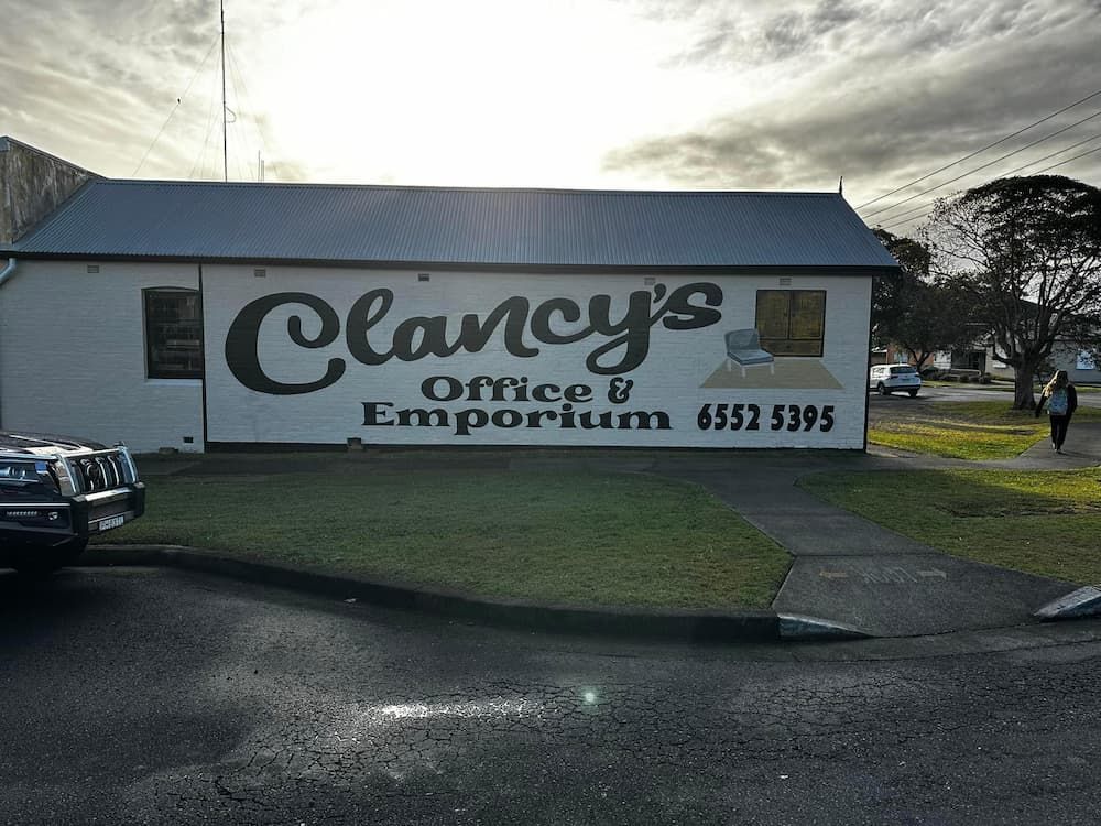 Two People Pose in Front of Clancy's Office & Emporium — Clancy's Office & Emporium in Taree, NSW