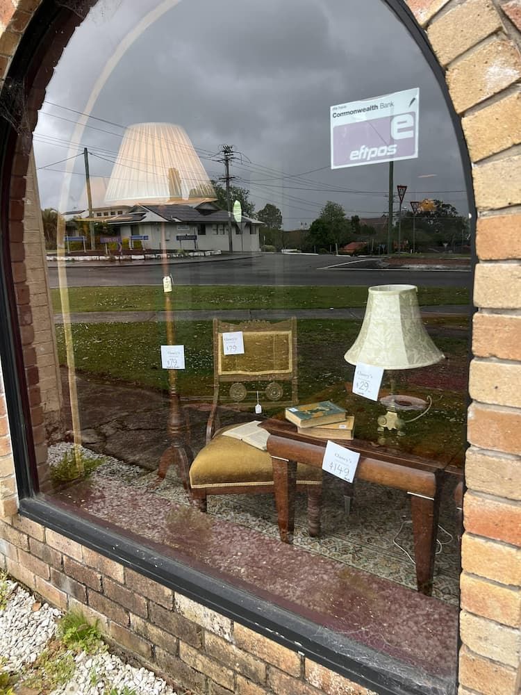 View Through a Shop Window Showcasing Vintage Furniture — Clancy's Office & Emporium in Taree, NSW