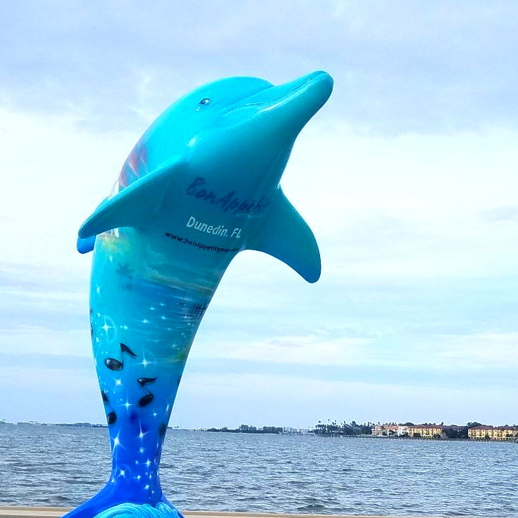 A statue of a blue dolphin with the word carlsbad on it