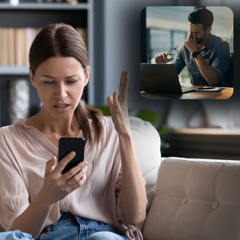 A woman is sitting on a couch looking at her phone