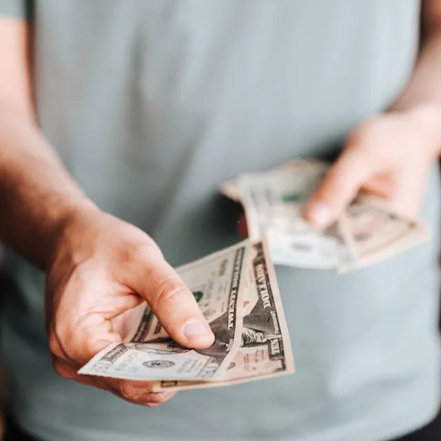 Cost to run Google ads phot of man handing out cash