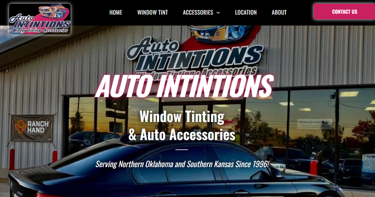 A car is parked in front of a building that says auto intintions window tinting and auto accessories.