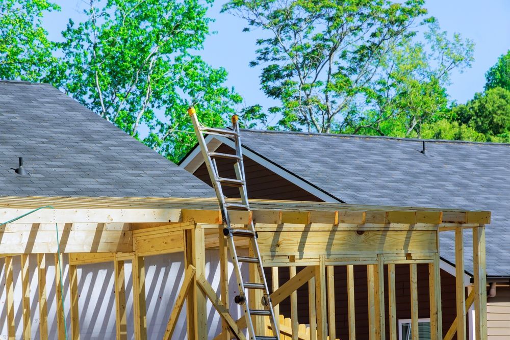 A ladder is sitting on top of a house under construction.