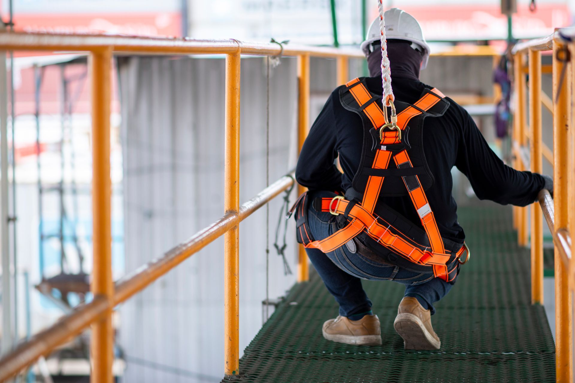 A construction worker wearing a safety harness. A construction worker wearing a safety harness.