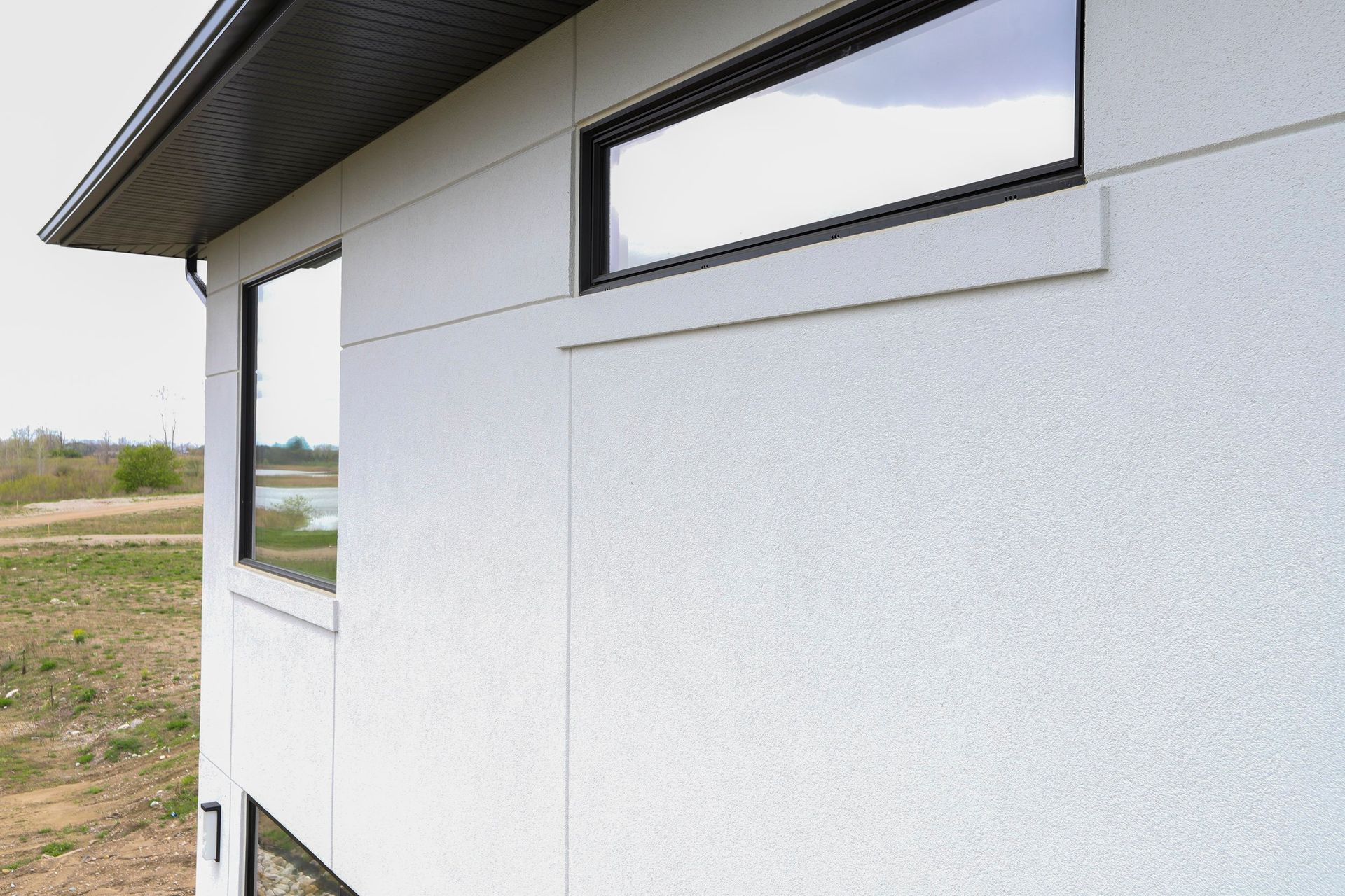 A white house with a large window on the side of it.