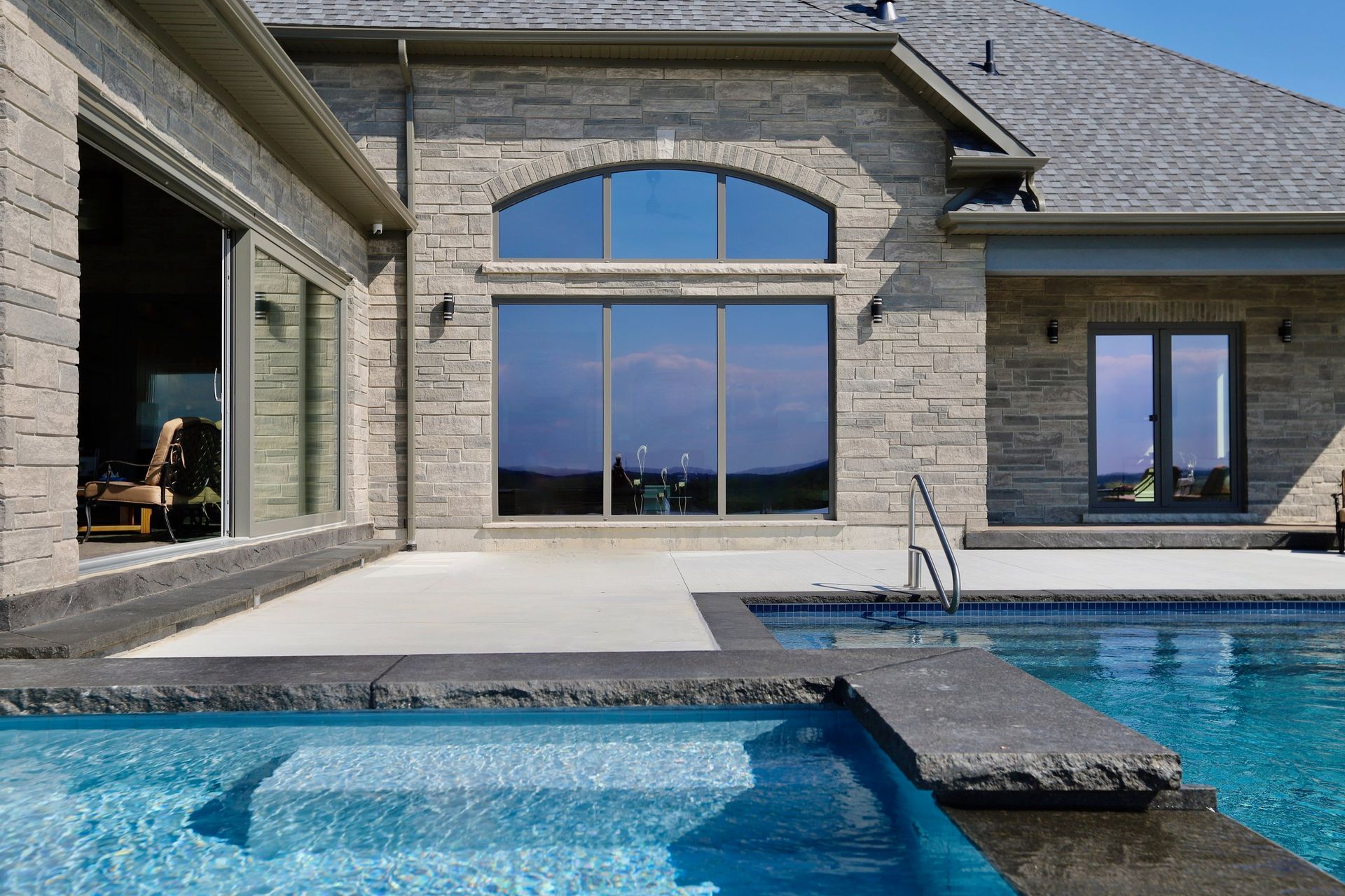 A large house with a swimming pool in front of it.