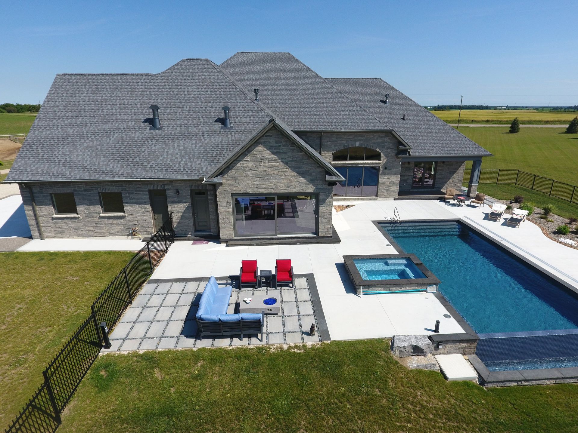 An aerial view of a large house with a large swimming pool