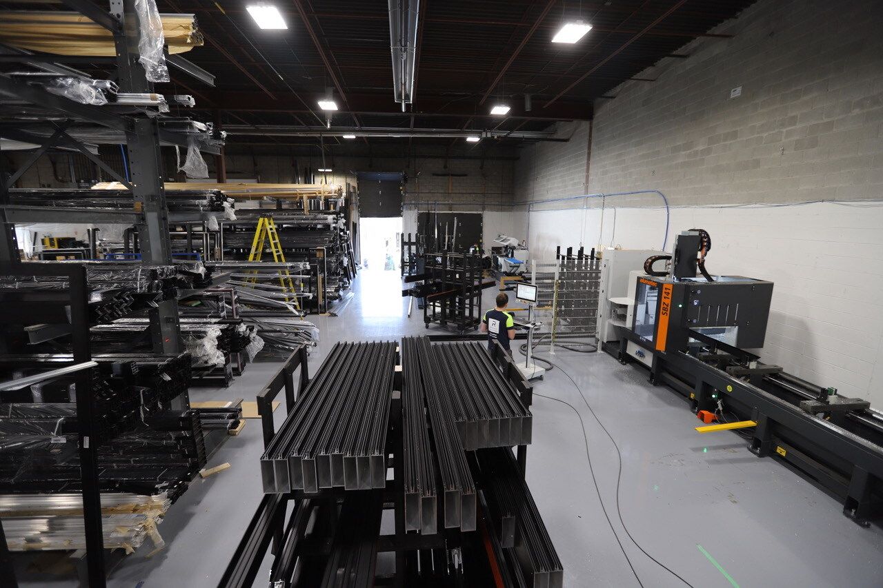 A warehouse with a lot of machinery and a lot of boxes on the floor.