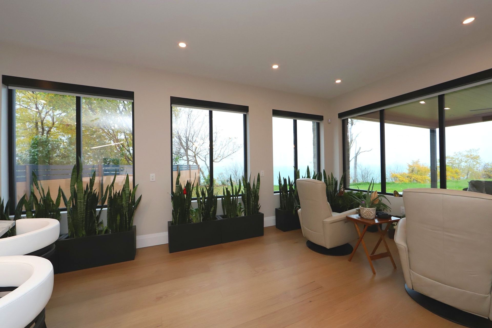 A living room with a lot of windows and chairs