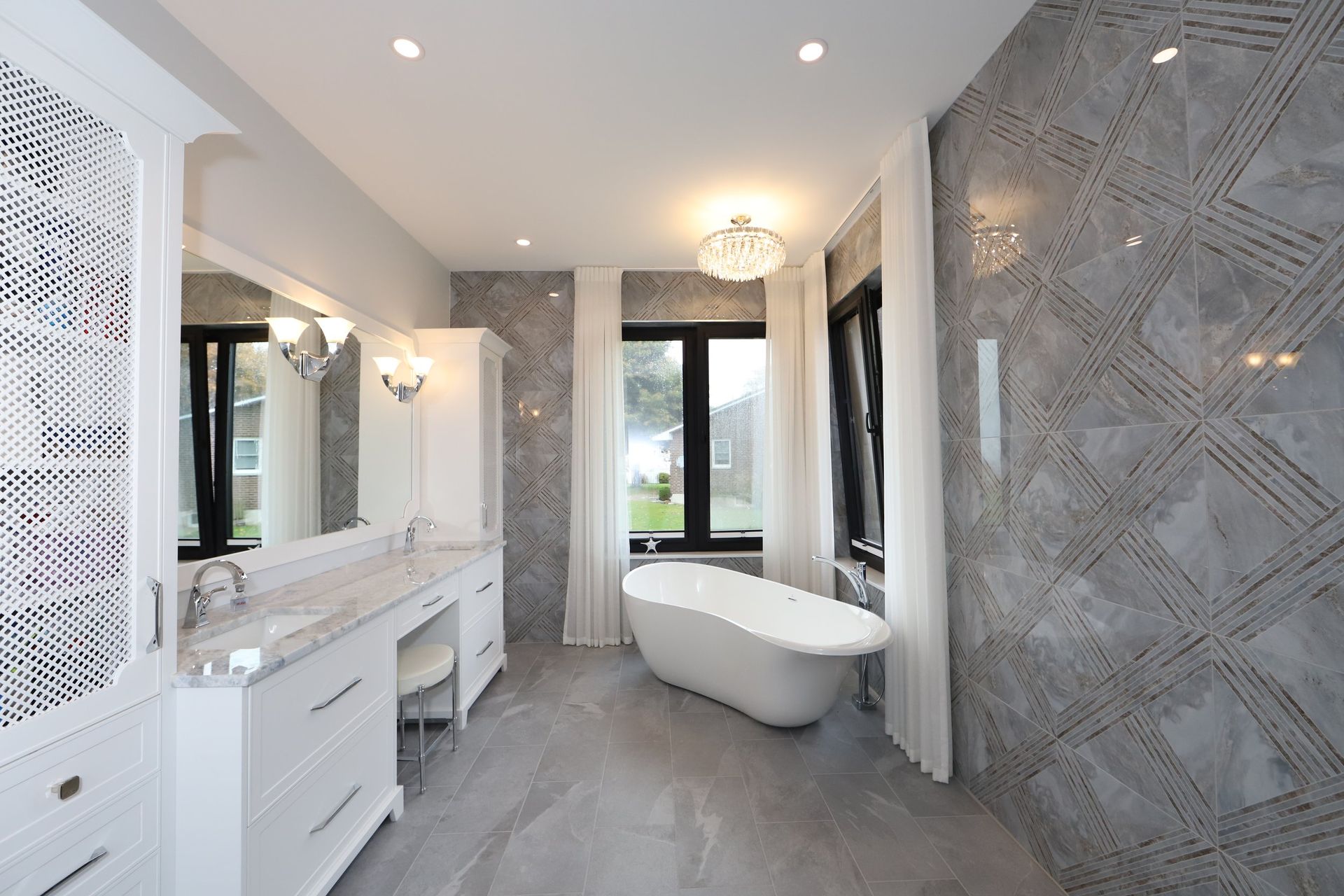 A bathroom with a tub , sink , mirror and window.
