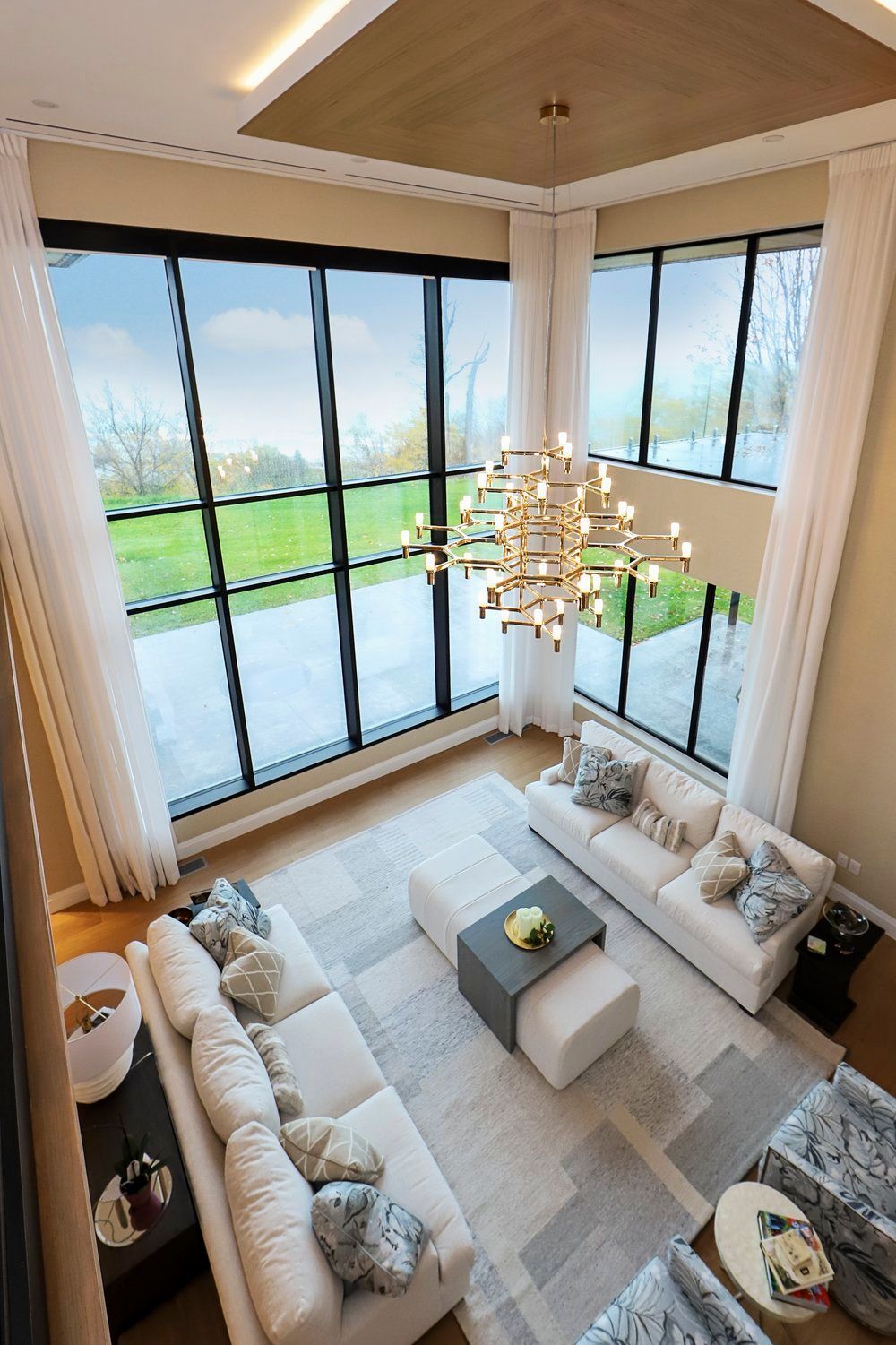 A living room with a lot of windows and a chandelier.