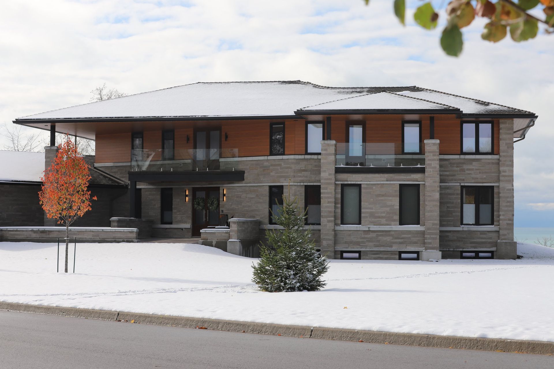 A large house with a lot of windows is covered in snow